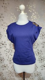 Blusa azul detalle prendedor dorado