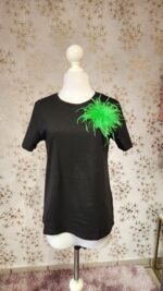 Blusa negra prendedor de plumas verde