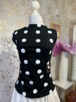 Blusa negra de lunares blancos con broche dorado en la cintura